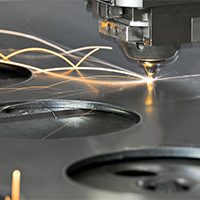 Laser metal cutting manufacturing tool in operation. Laser metal cutting manufacturing tool in operation.